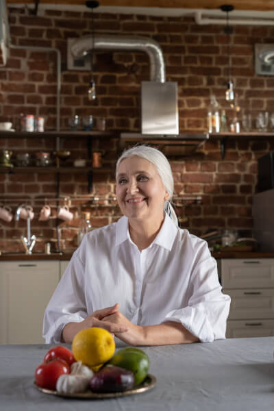 Lächelnde Frau mit Obstschale in einer Küche